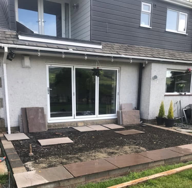 Before: bare ground behind a modern extension with bi-fold doors