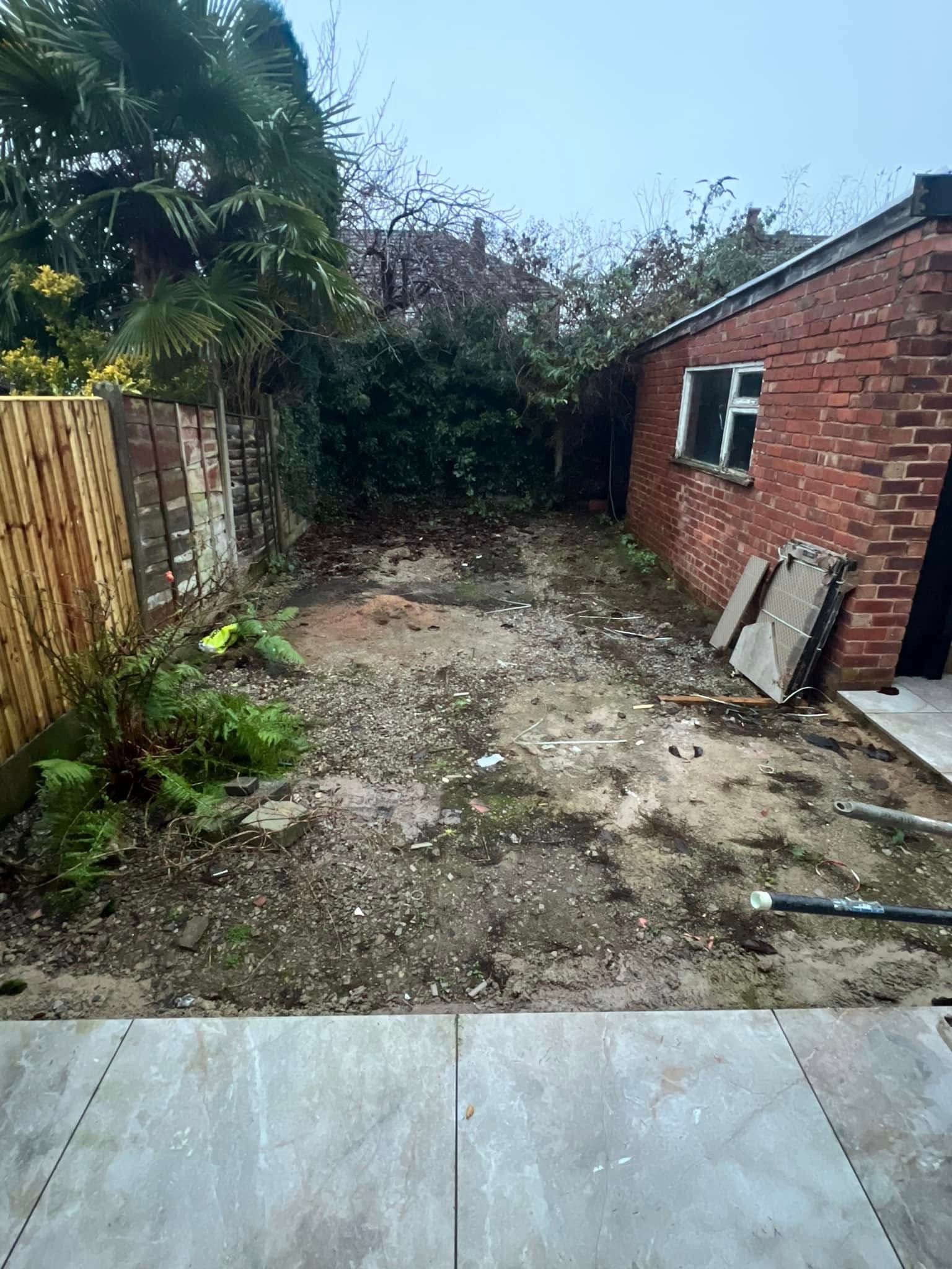 Before: bare garden plot next to brick outbuilding