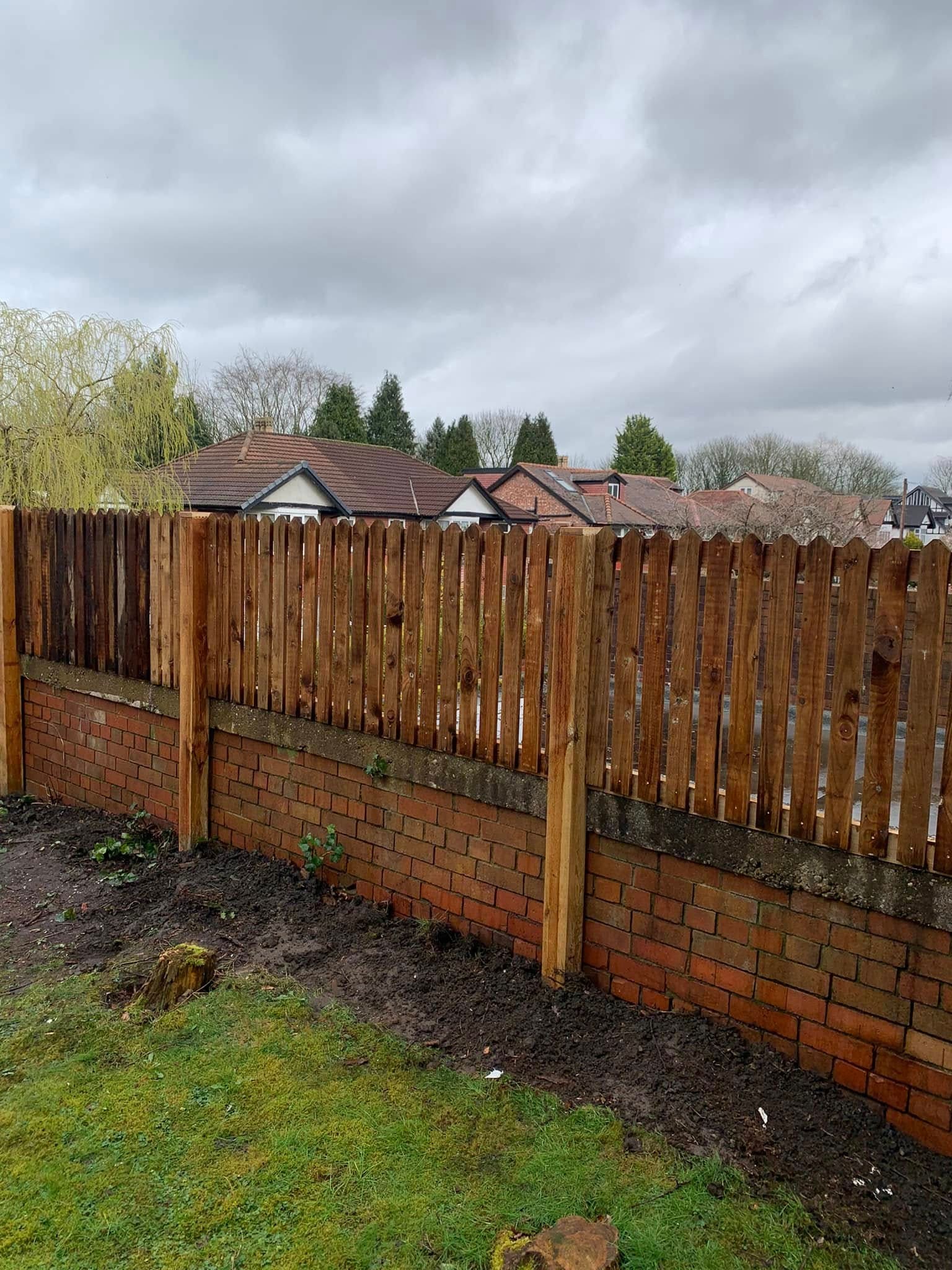 New timber fence panels installed on a brick wall boundary